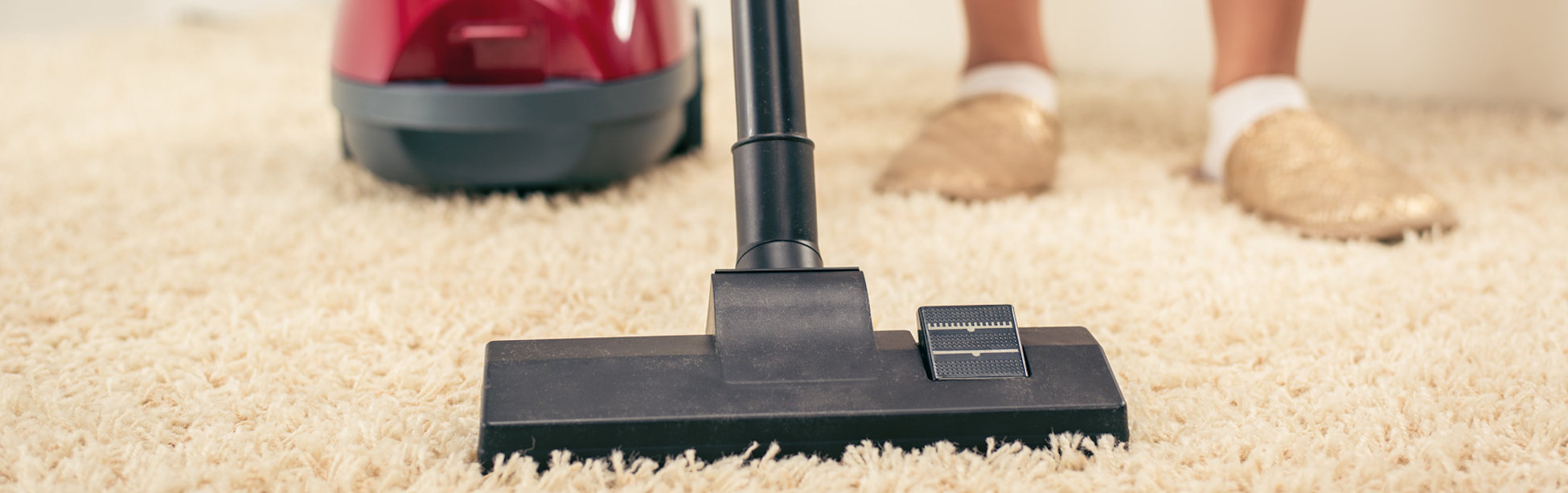 Woman vacuuming the house. Close-up with vacuum cleaner.